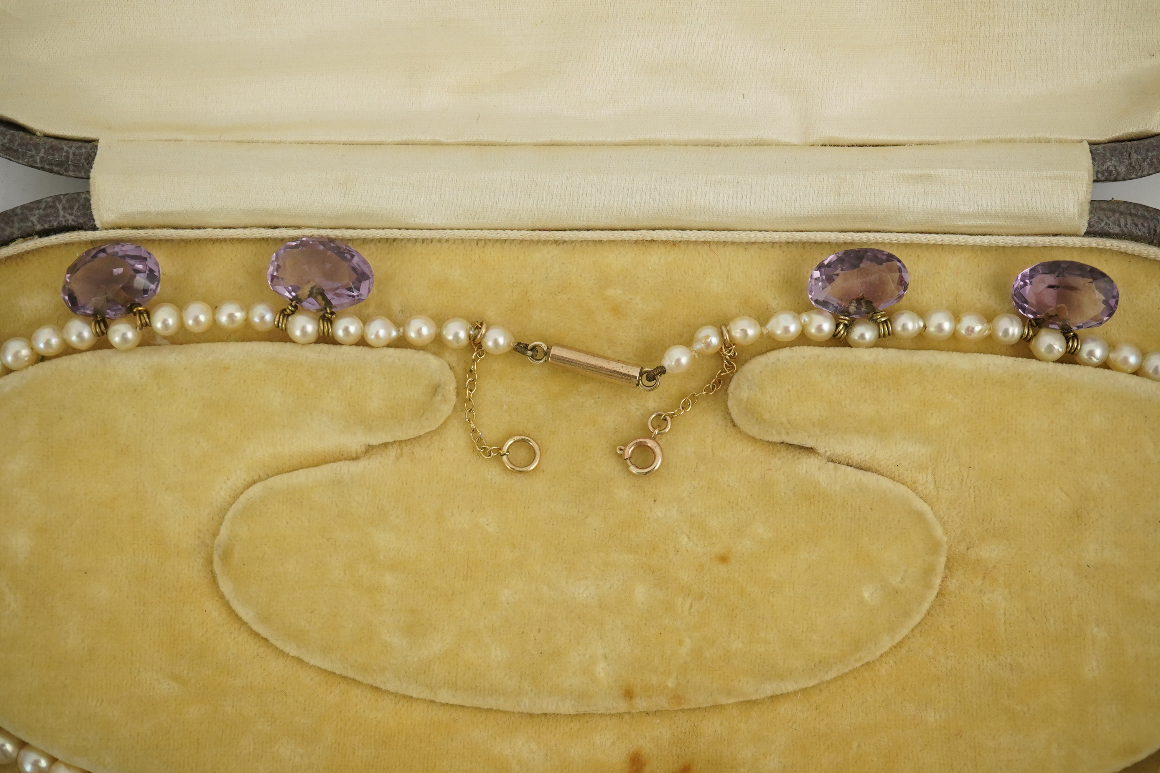 A 19th century pearl and graduated fifteen stone oval cut amethyst set drop necklace, with a gold barrel shaped clasp